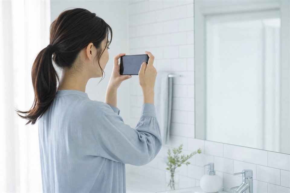 洗面所でスマートフォンを構えて撮影するところ